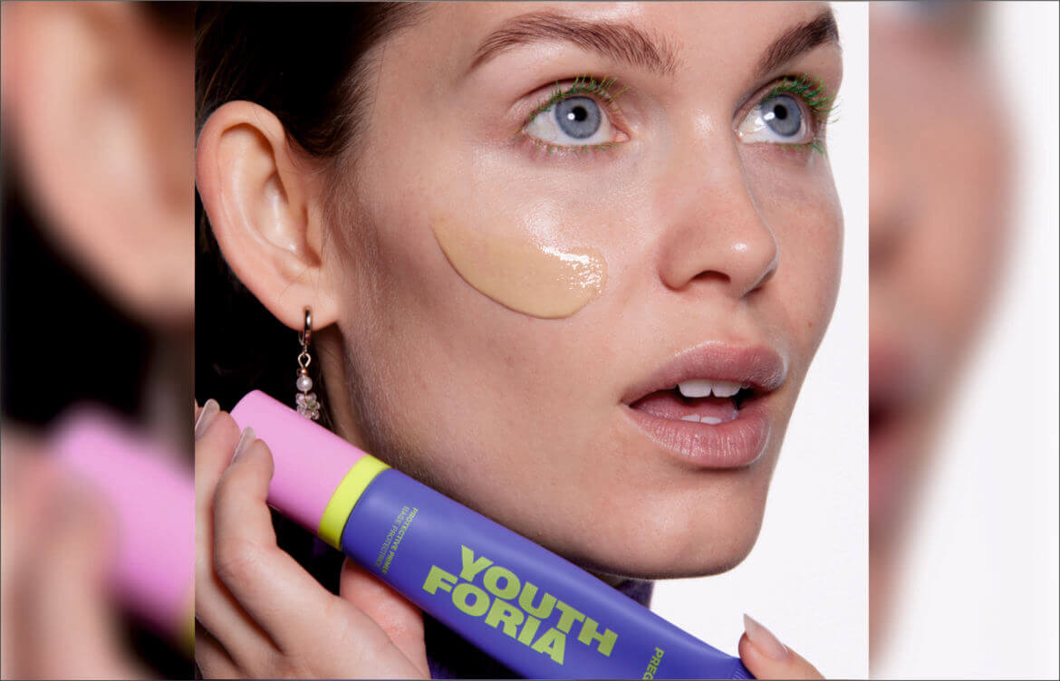 A woman holding a Youthforia product.